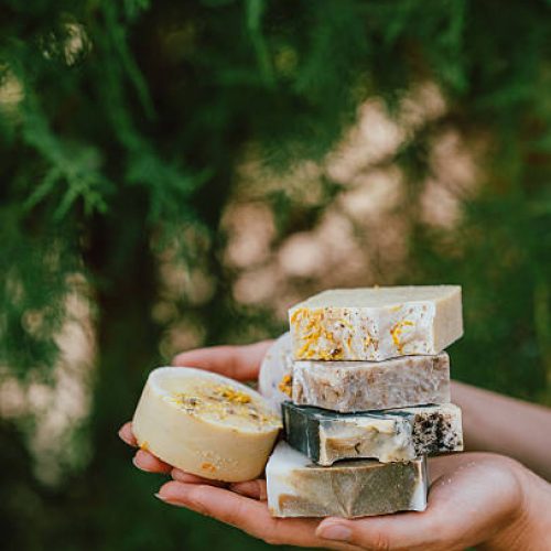 outdoor artisan soap stacking with bright colors, handmade soaps arranged outdoors in sunny garden